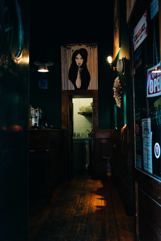 FineArt_Kärnten_Zaunschirm_roma-91 Langer Gang einer Bar mit Frauenbild über der Tür